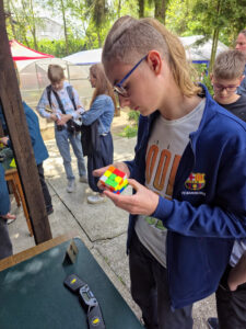 Młody mężczyzna rozwiązuje kostkę Rubika na wydarzeniu Rubik’s Madness 2026