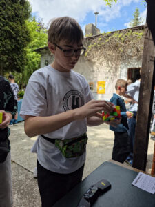 Chłopiec rozwiązuje kostkę Rubika na zawodach Rubik's Madness 2026