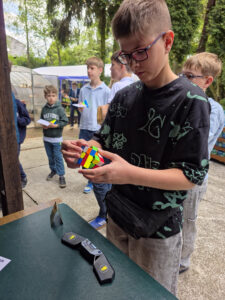 Chłopiec rozwiązuje kostkę Rubika na zawodach Rubik’s Madness 2026.