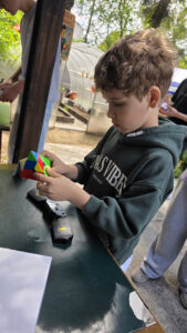 Chłopiec rozwiązuje kostkę Rubika na zawodach Rubik's Madness 2026