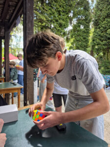 Chłopiec układa kostkę Rubika na stole podczas zawodów Rubik’s Madness 2026.