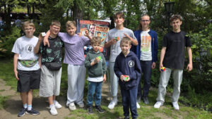 Grupa chłopców z kostkami Rubika przed plakatem „Rubik's Madness”