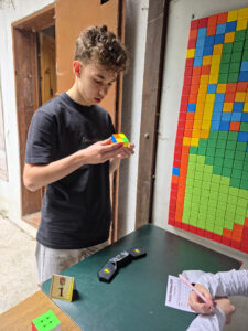 Młody mężczyzna rozwiązuje kostkę Rubika na zawodach Rubik's Madness 2026.