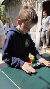 Chłopiec rozwiązuje kostkę Rubika na zawodach Rubik’s Madness 2026
