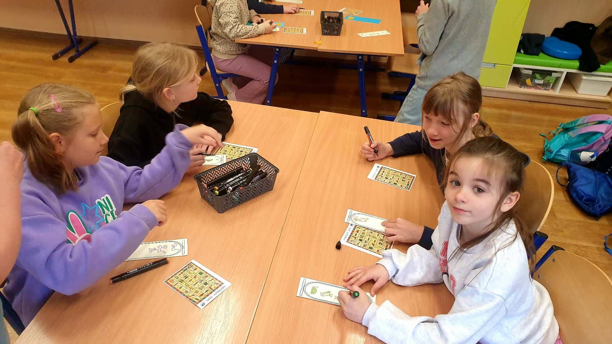 Dzieci rysują na kartach w szkole.