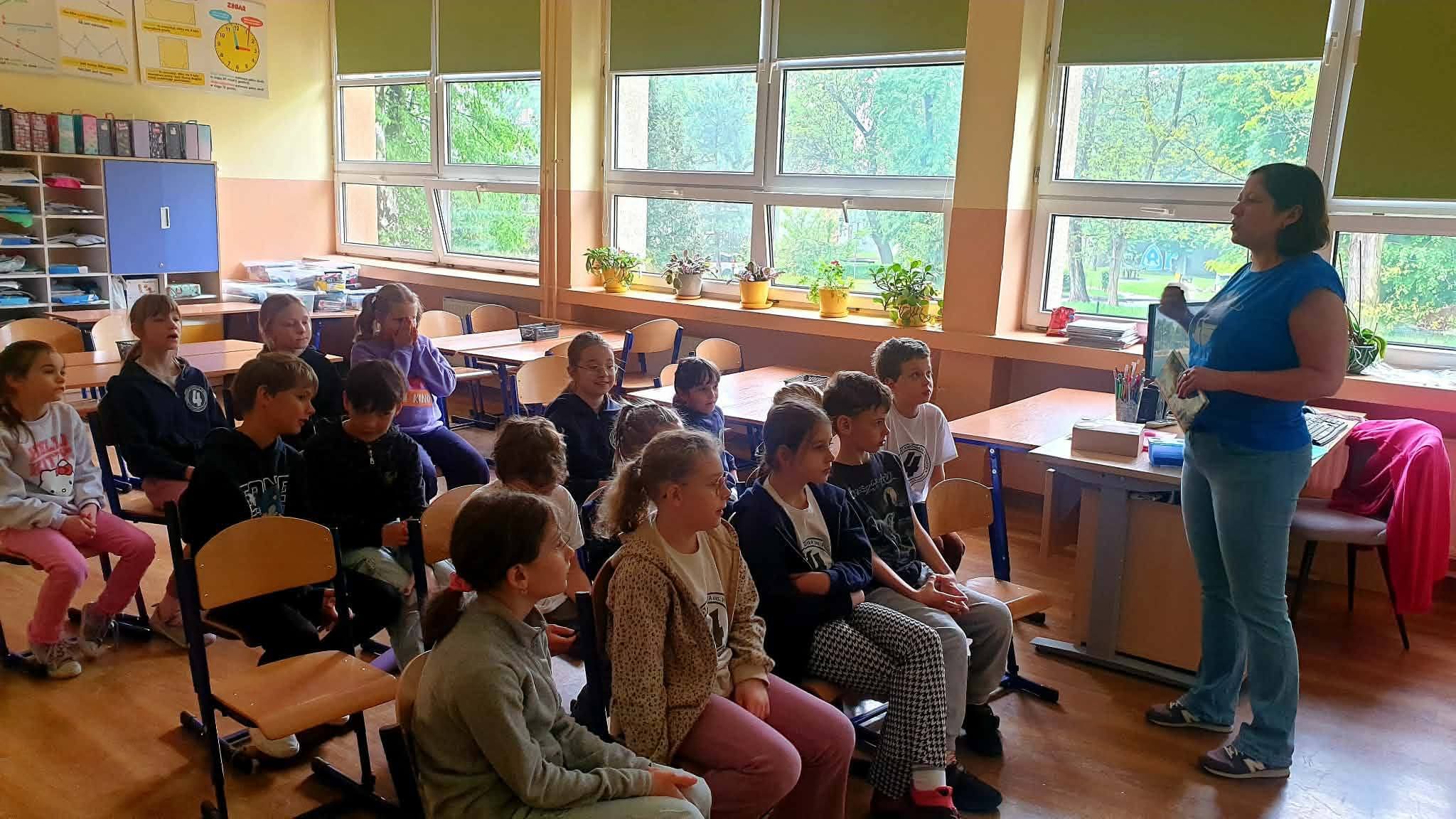 Nauczycielka czyta książkę dzieciom w klasie.